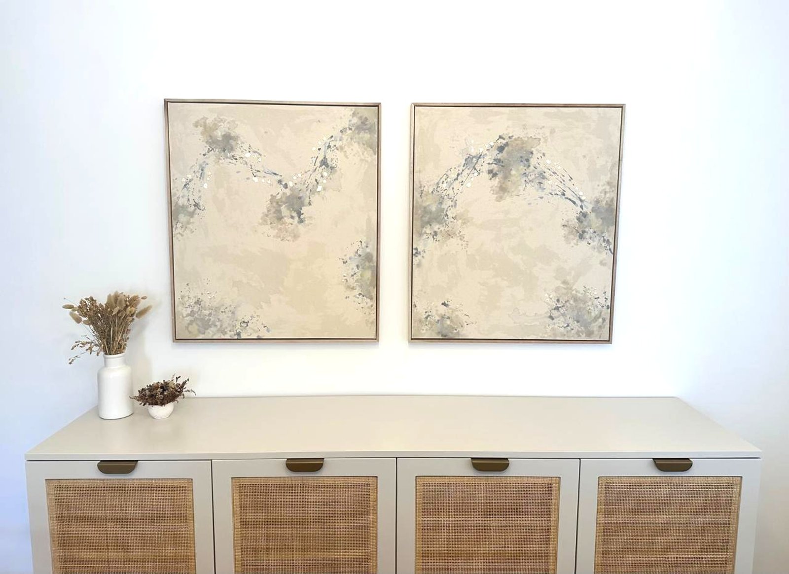 mueble bajo de rattan con arte abstracto sobre pared blanca — proyecto Nicaragua, por Eniraestudio, en Buenos Aires